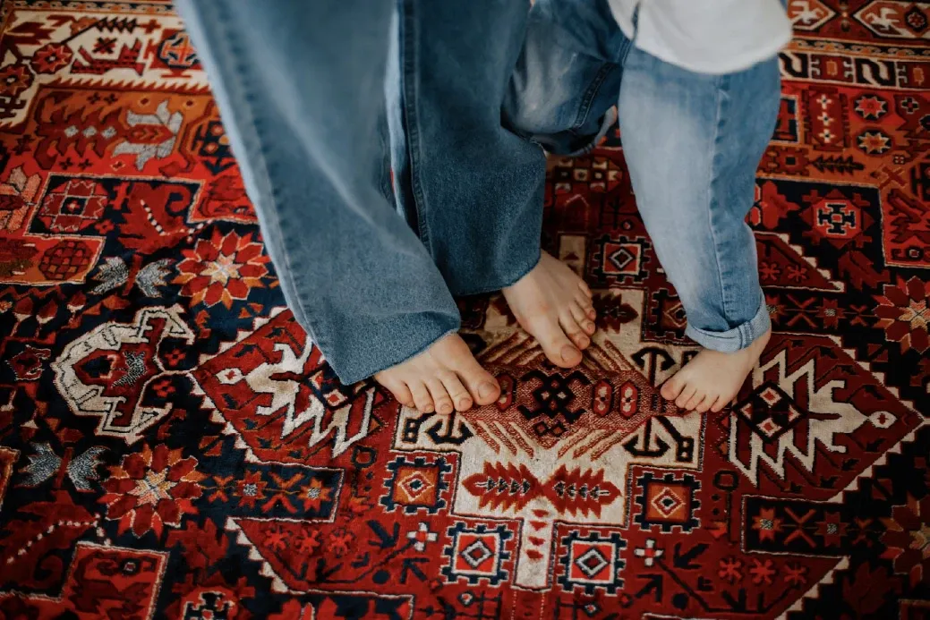 Pies descalzos sobre una alfombra roja de diseño tribal